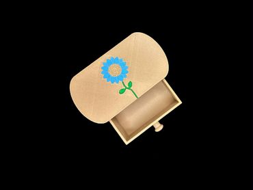 Small wooden box with blue flower decoration, open and empty.