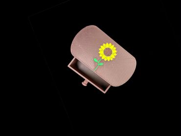 Open brown box with a sunflower design on the lid.