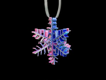 A colorful snowflake pendant with intricate details on a black background.