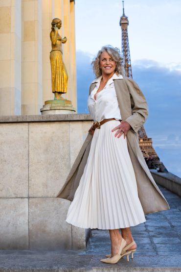Woman posing near Eiffel Tower with golden statue.