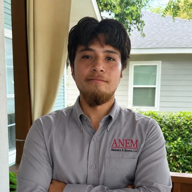 Man in gray shirt with crossed arms.