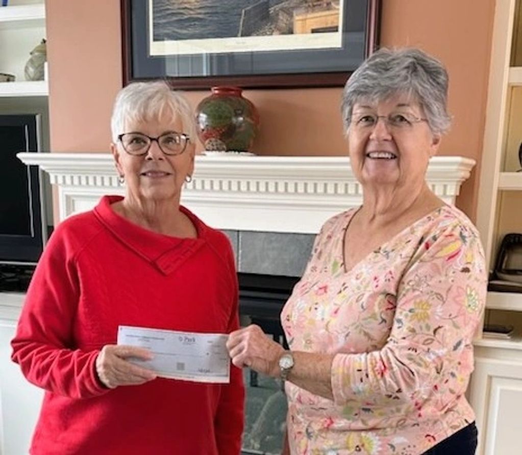 Nancy Boyd, president presenting check to Jayne Roblin, treasurer.