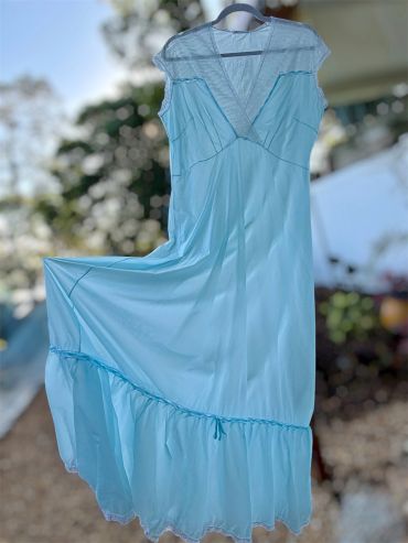 Light blue dress hanging outdoors on a hanger.