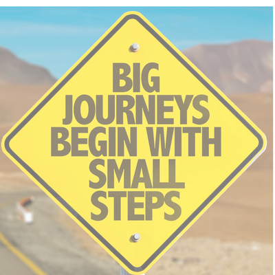 Motivational sign about journeys and small steps.