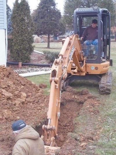 Mini excavator digging trench