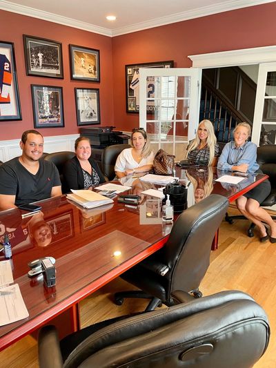 Five people sitting around a conference table in an office.