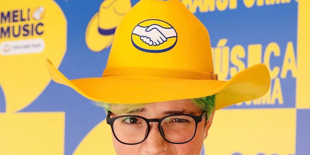 Person wearing a bright yellow cowboy hat with a handshake logo.