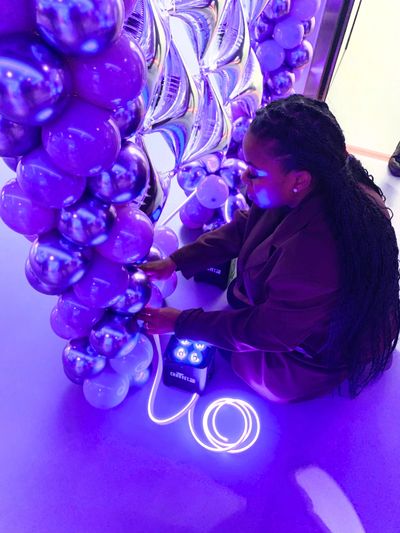 event stylist fixing balloon arch and adding LED rope