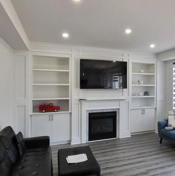 Modern living room with black and blue sofas, fireplace, and TV.