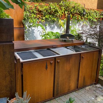 Bespoke weathered corten steel garden kitchen with smeg electric hobs and foldable tap sink 
