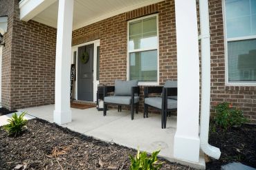 Cozy porch with two chairs and a small table.