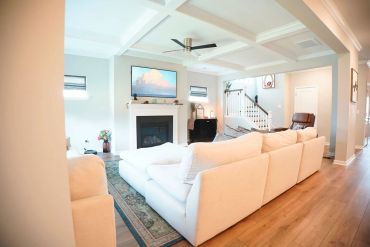 Bright and cozy living room with white furniture and fireplace.