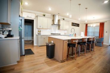 Modern kitchen with island and wooden flooring.