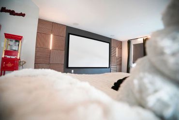 Home theater room with projector screen and popcorn machine.