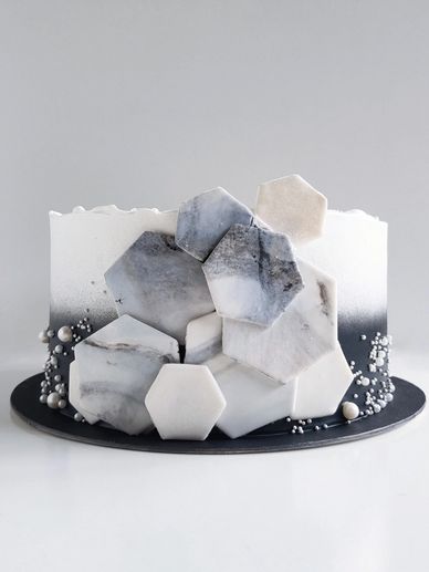 Elegant black and white geometric marble cake with hexagonal accents.
