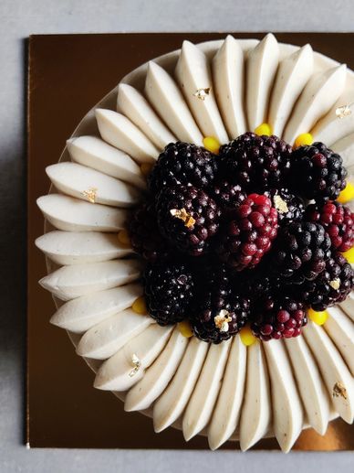 Elegant cake topped with fresh blackberries and creamy frosting.