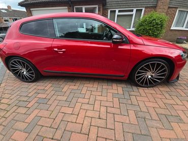 Driver side of red Volkswagen Scirocco showing gloss and clean finish