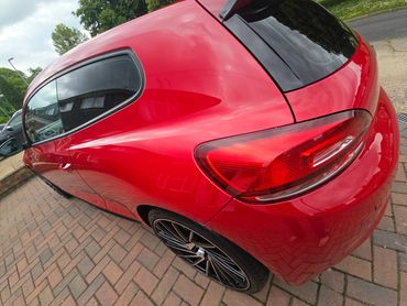 Rear 3/4 of red Volkswagen Scirocco showing paintwork symmetry after detail