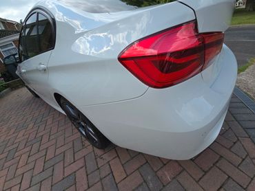 Rear 3/4 of white BMW 320 showing paintwork symmetry after detail