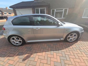 Driver side of grey Alfa 147 showing gloss and clean finish