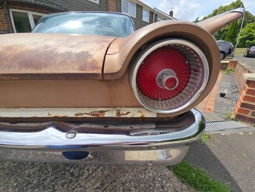Ford Fairlane rear light and metal bumper showing shine
