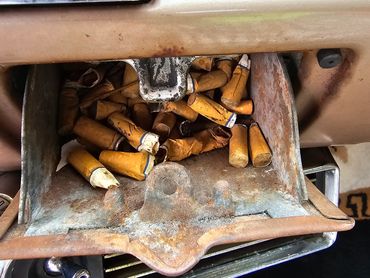 Interior Ford Fairlane ashtray filled uop with cigarettes
