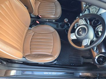 Interior of brown Mini Cooper looking down at the drivers seat