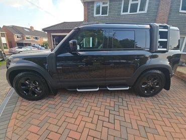 Passenger side of black Range Rover Defender showing polish and tyre shine