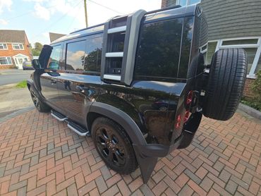 Rear 3/4 of black Range Rover Defender showing paintwork symmetry after detail