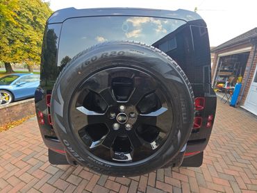 Rear of black Range Rover Defender with boot gloss and clean spare wheel finish
