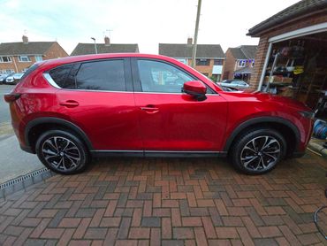 Driver side of red Mazda CX-5 showing gloss and clean finish