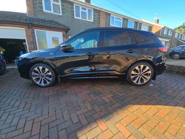 Passenger side of black Ford Kuga showing polish and tyre shine
