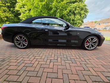 Side profile of a black BMW 440i after a full detail in Salisbury, showcasing machine-polished panel