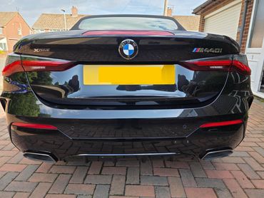 Rear end BMW after full Revive including machine polishing, with clear reflections on the bumper