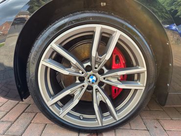 Passengers side front alloy wheel and brake caliper on BMW, detailed by AM Auto Aesthetics