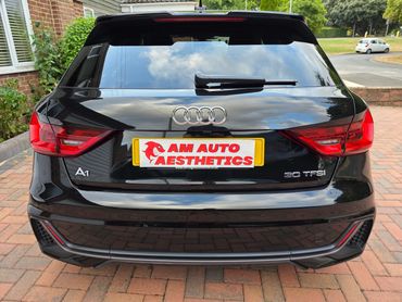 Rear view of a black Audi A1 30 TFSI parked on a brick driveway.