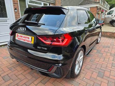 Sleek black Audi A1 30 TFSI parked on a brick driveway.