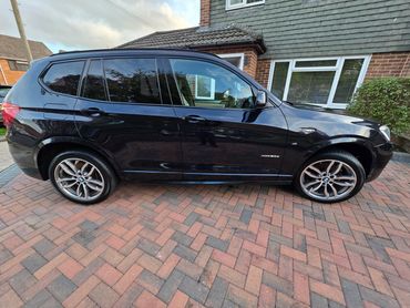 Driver side of blue BMW X3 showing gloss and clean finish