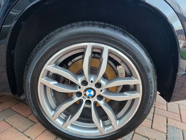Wheel and caliper of blue BMW X3 cleaned by AM Auto Aesthetics