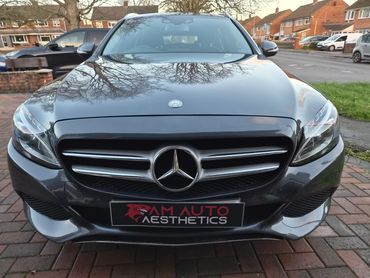 Front view of a sleek black Mercedes-Benz car with AM Auto Aesthetics plate.