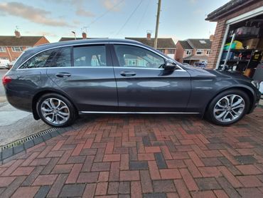 Gray station wagon parked on a driveway in a residential area.