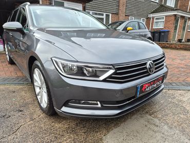 A sleek gray Volkswagen car parked in a residential driveway.