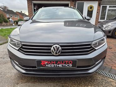 Front view of a gray Volkswagen car parked outside a house with AM Auto Aesthetics plate.