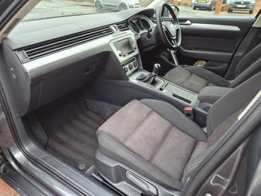 Interior of a modern car with fabric seats and manual transmission.