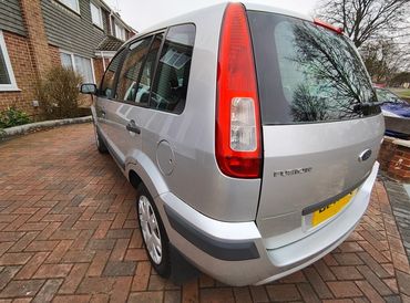 Rear 3/4 of silver Ford Fusion showing paintwork symmetry after detail