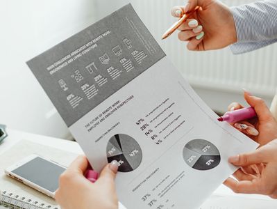 Hands holding a report with pie charts and data visuals.