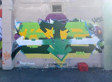 Bold graffiti mural with vibrant colors and layered abstract shapes, created on a Columbus street