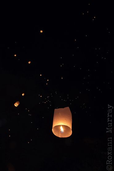 Hundreds of paper lanterns are released into the night sky during a Loi Krathong festival.
