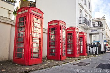 Red telephone booths are lined in a row in London.
