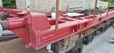 Part of a red train chassis or freight car frame.